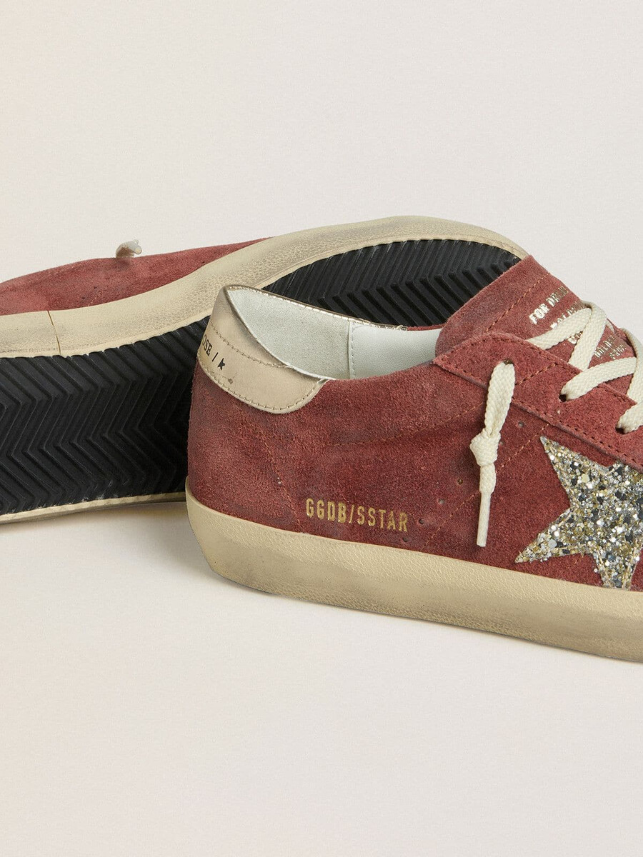 dames super-star ltd in rood suède met zilveren glitterster en hielstuk van gelamineerd leer.