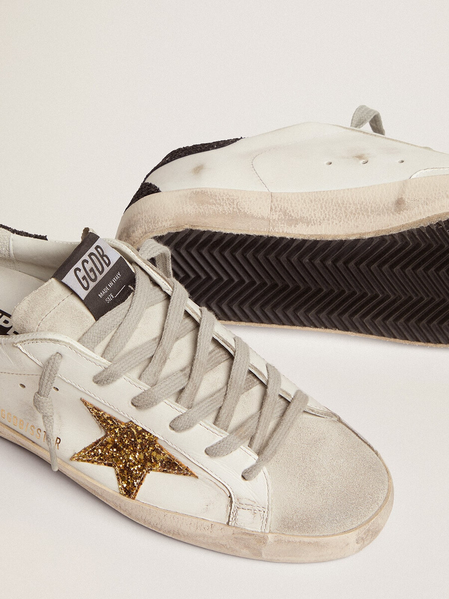 dames super-star in nappaleer met gouden glitterster en zwarte glitterhiel.
