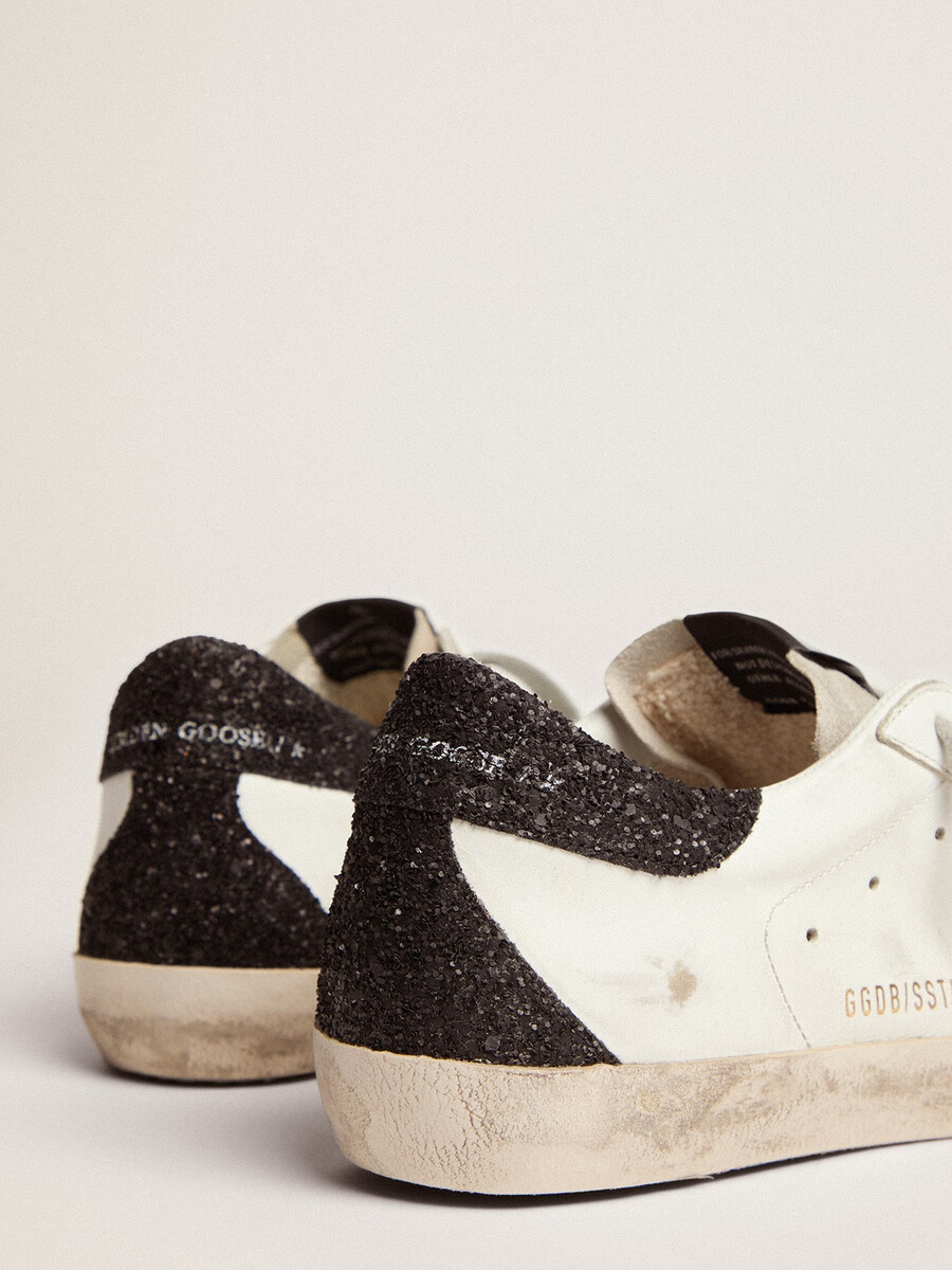 dames super-star in nappaleer met gouden glitterster en zwarte glitterhiel.