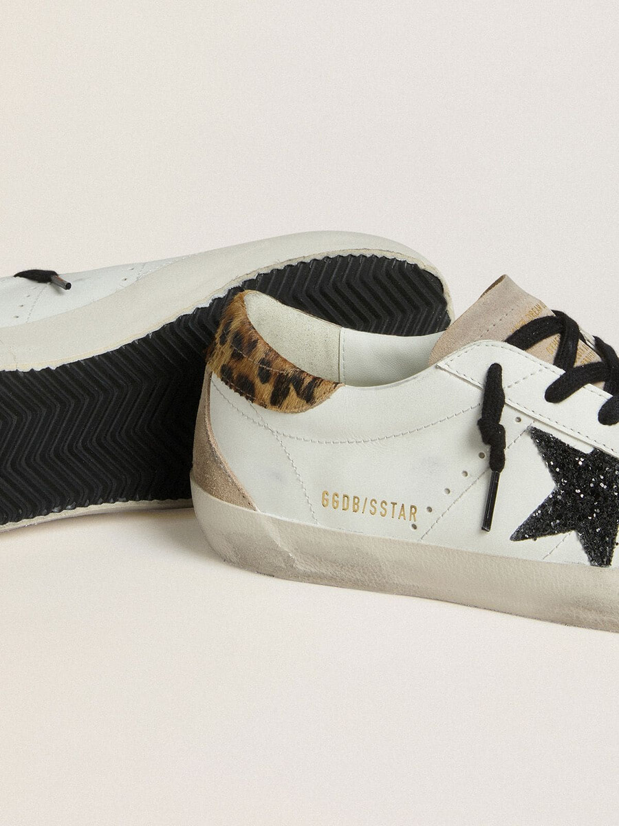 dames super-star met zwarte glitterster en hielstuk van ponyhuid met luipaardprint.