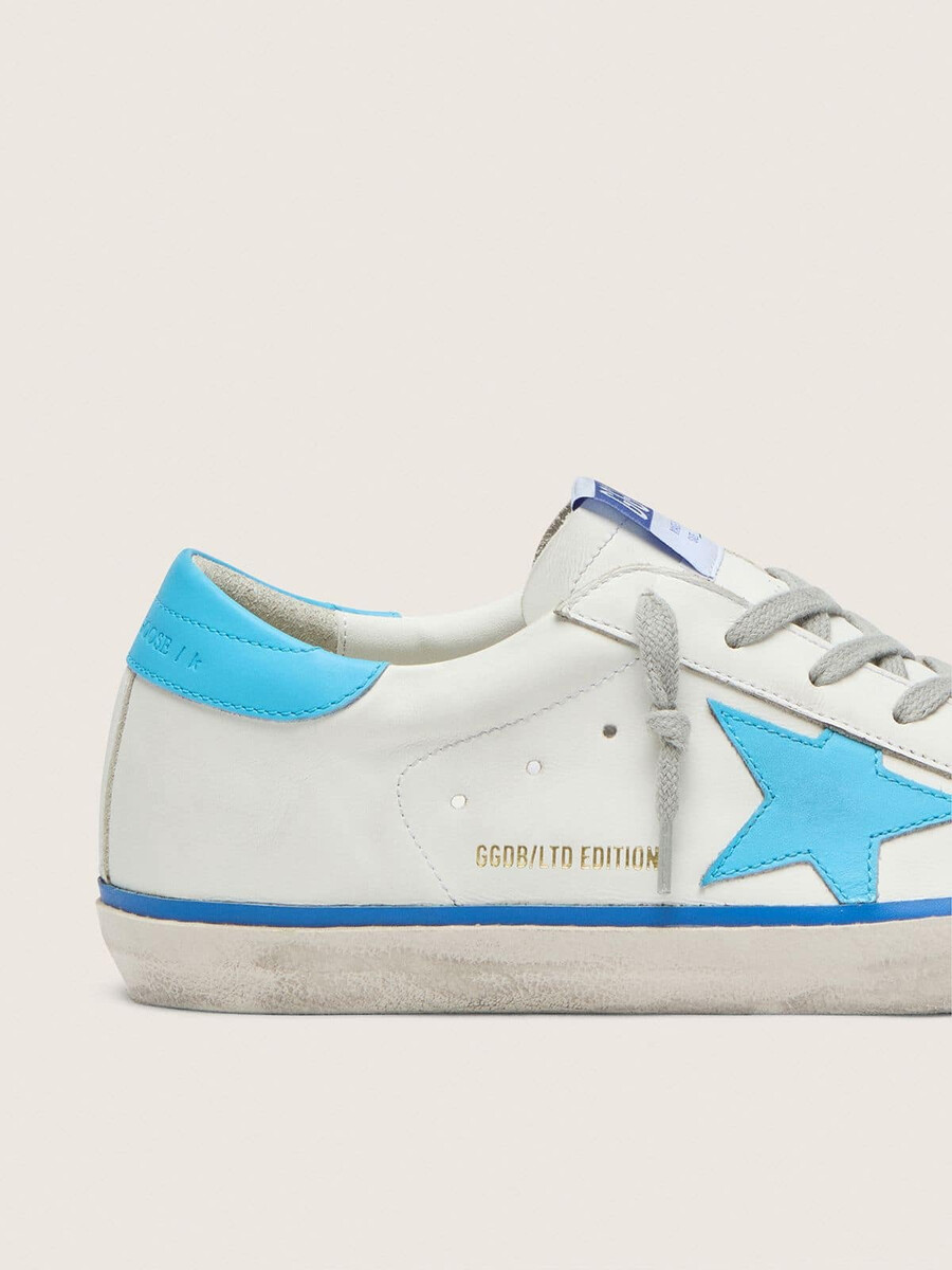 dames super-star ltd in wit leer met lichtblauwe leren ster en hielstuk.