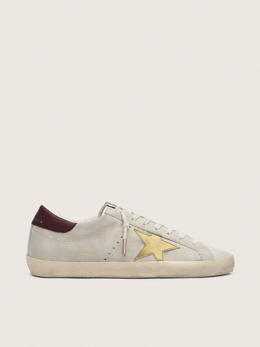 dames super-star cny in ivoorkleurig suède met metallic leren ster en leren hielstuk.