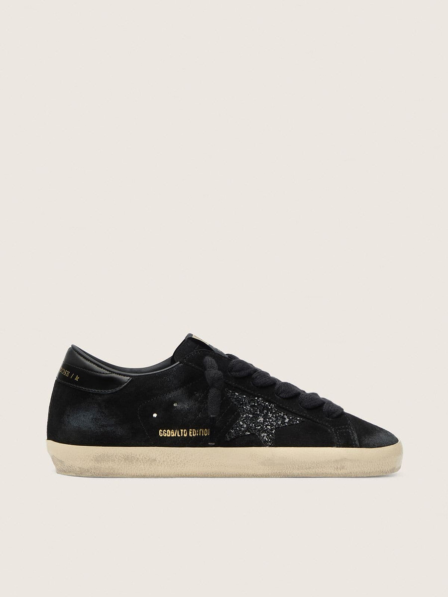 dames super-star ltd in zwart suède met zwarte glitterster en zwart leren hielstuk.