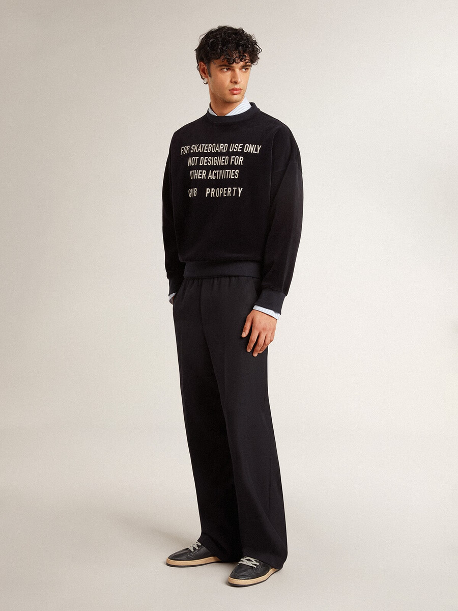 zwarte sweater met ronde hals en geborduurde letters.
