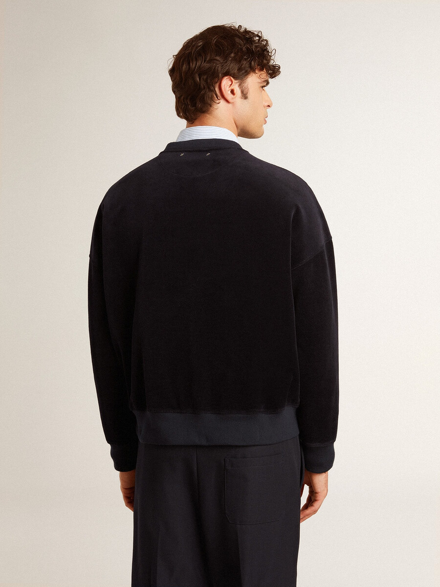 zwarte sweater met ronde hals en geborduurde letters.