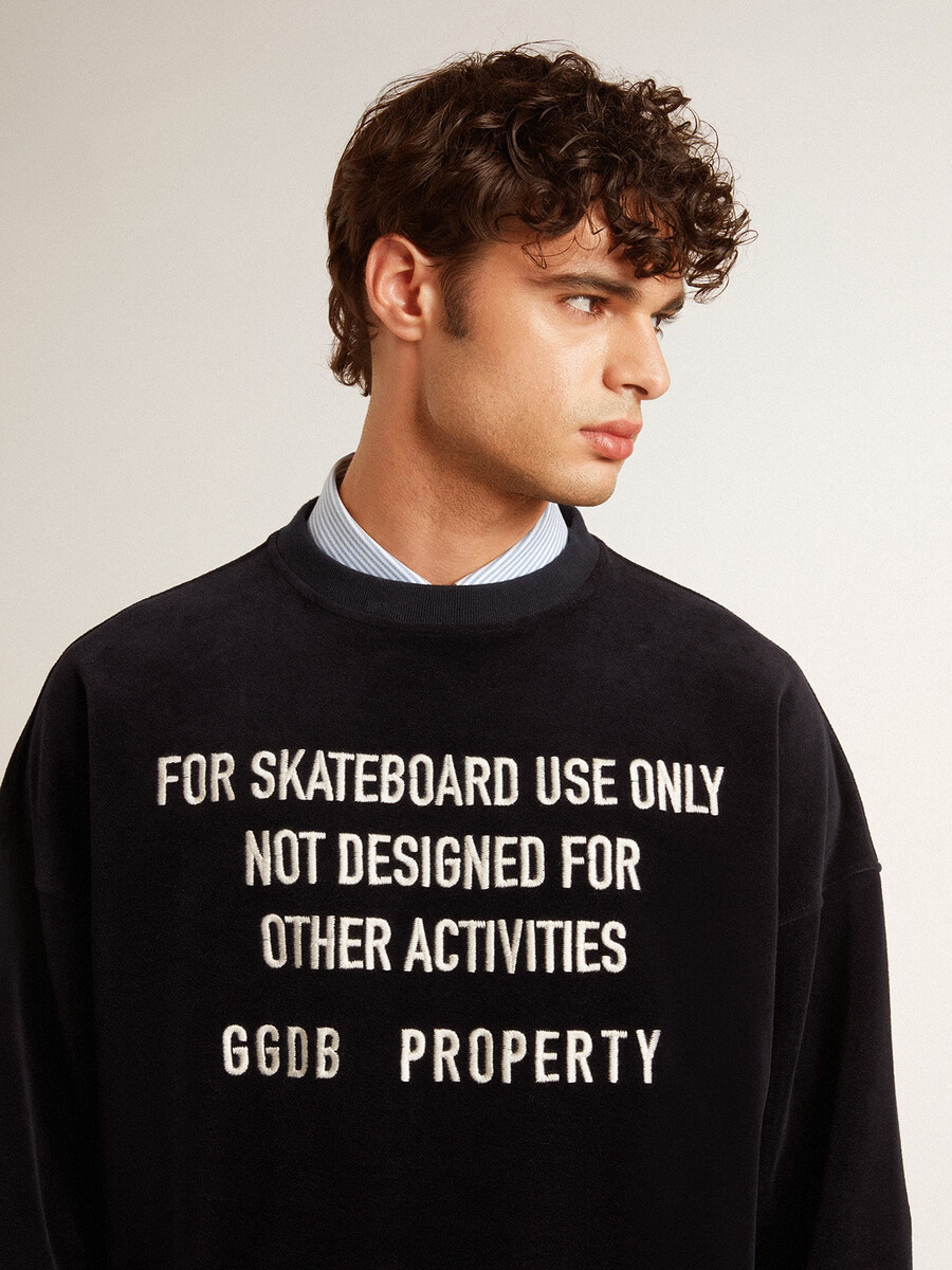 zwarte sweater met ronde hals en geborduurde letters.