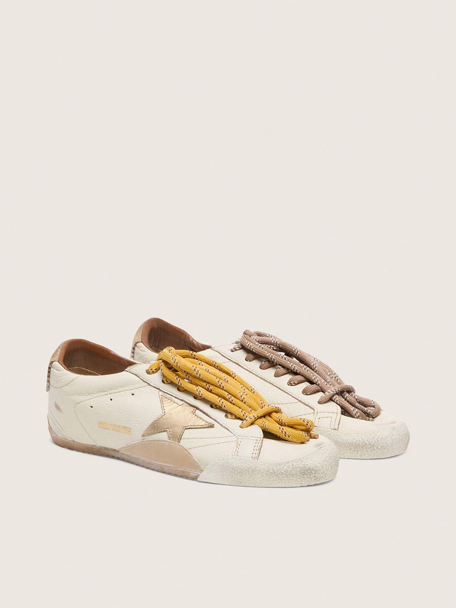 true-star herenschoen in wit nappaleer met een goudkleurige leren ster en een hielstuk van beige suède.