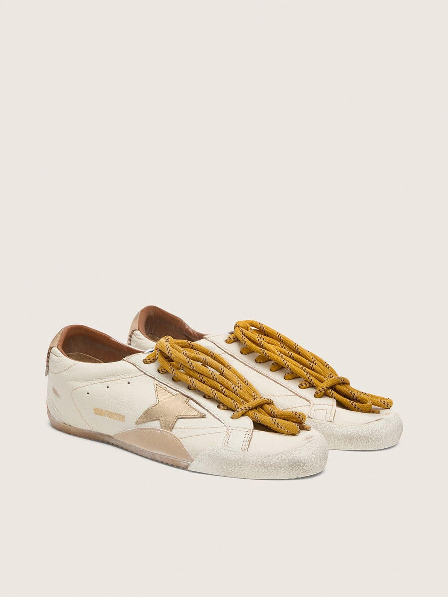 true-star herenschoen in wit nappaleer met een goudkleurige leren ster en een hielstuk van beige suède.