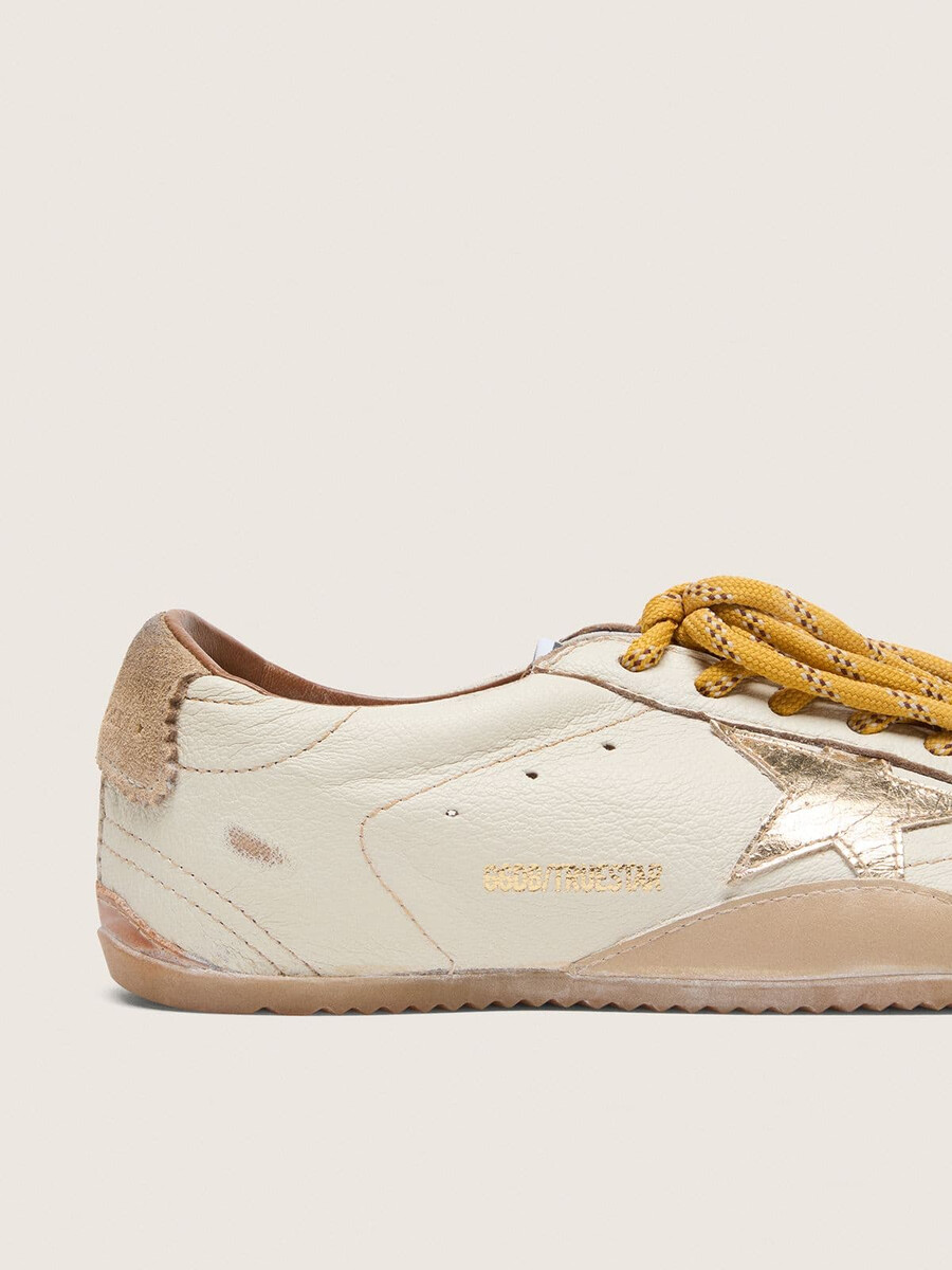 dames true-star in wit nappaleer met gouden ster en beige suède hielstuk.