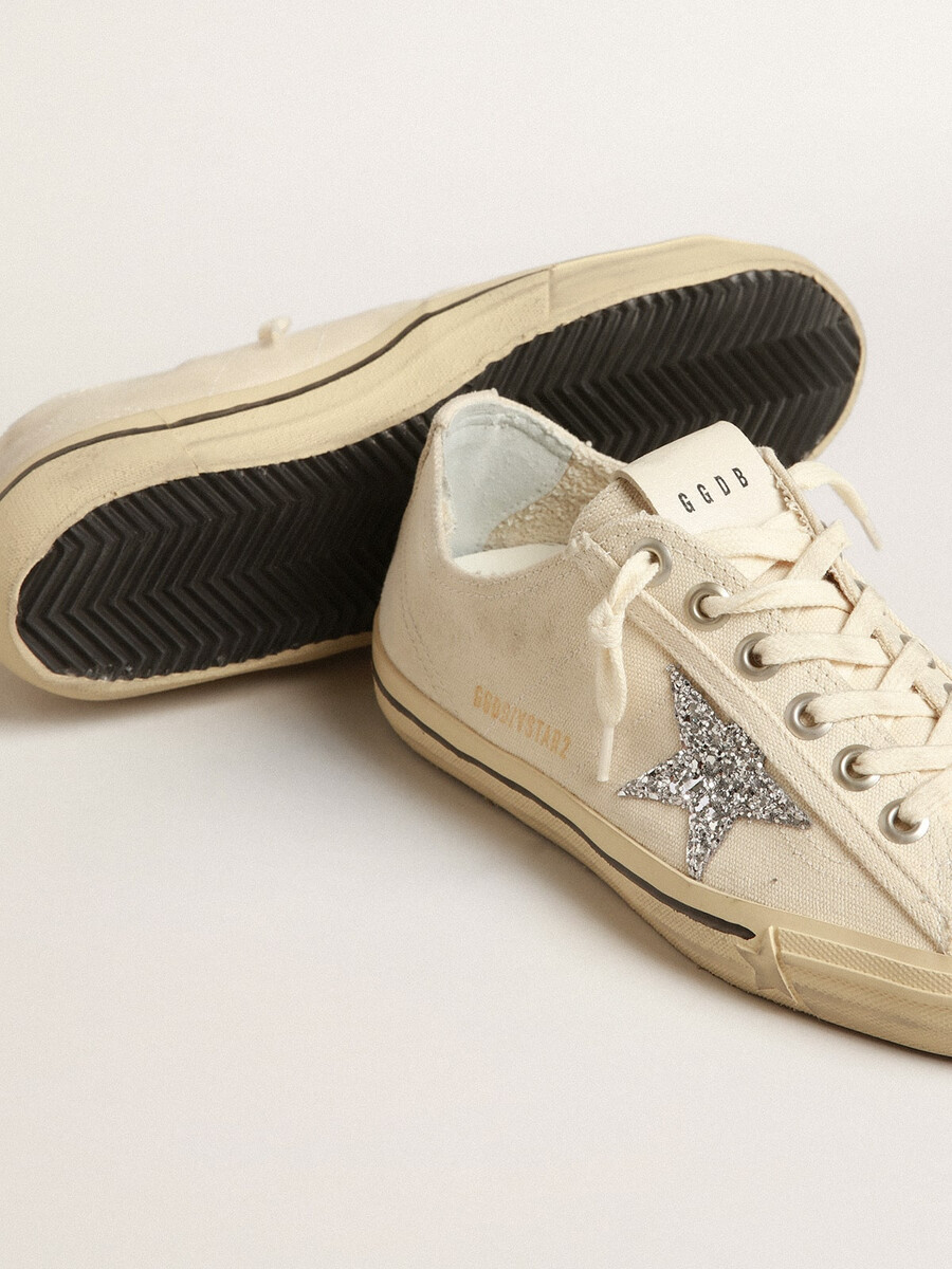 v-ster in beige canvas met een zilveren glitterster.