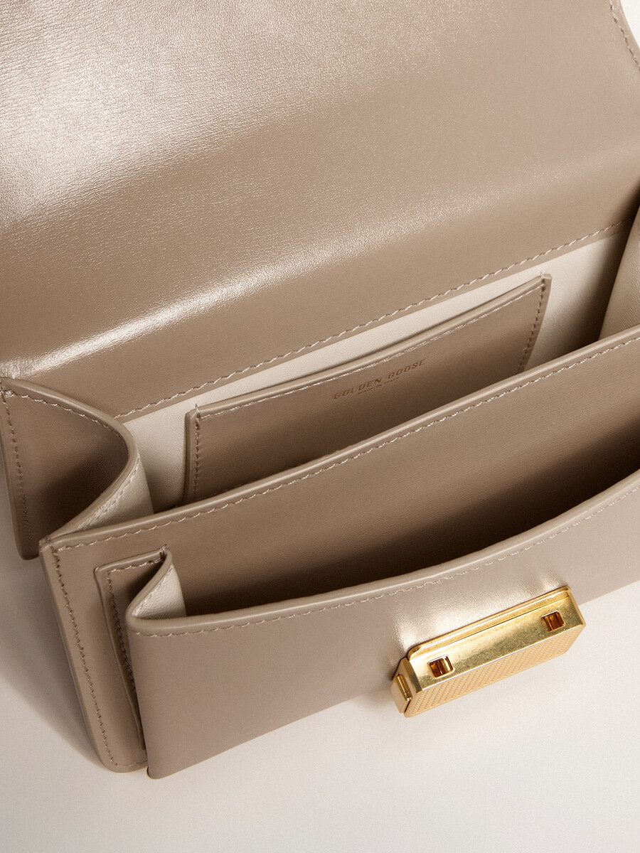 kleine venezia-tas van beige geribbeld leer met gouden details.