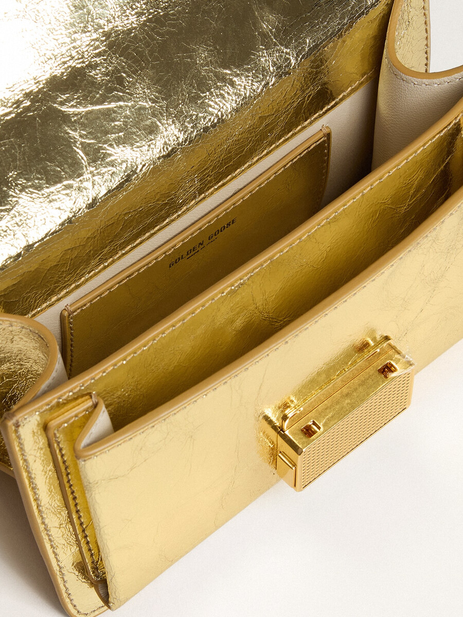 kleine venezia-tas van goudkleurig metallic leer met gouden details.
