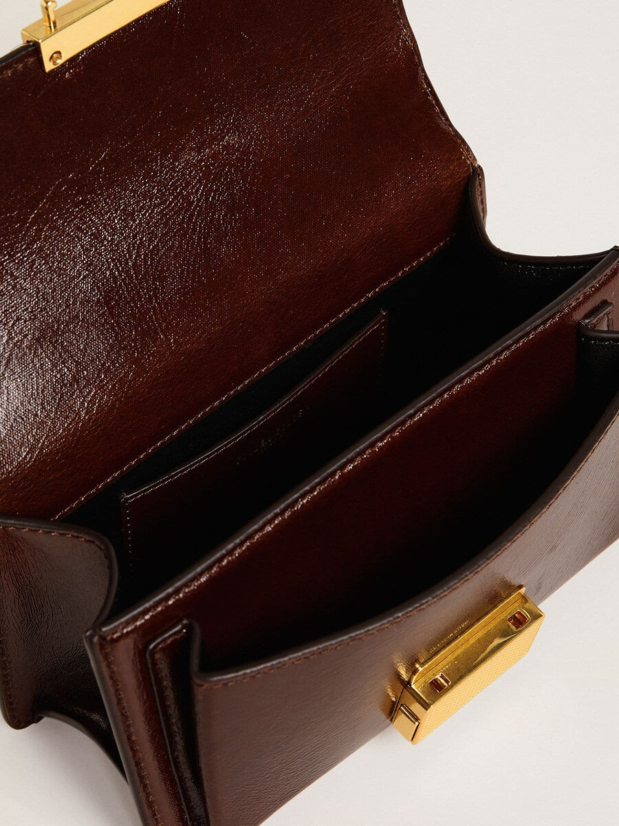 kleine venezia-tas van donkerbruin gelamineerd leer met gouden details.
