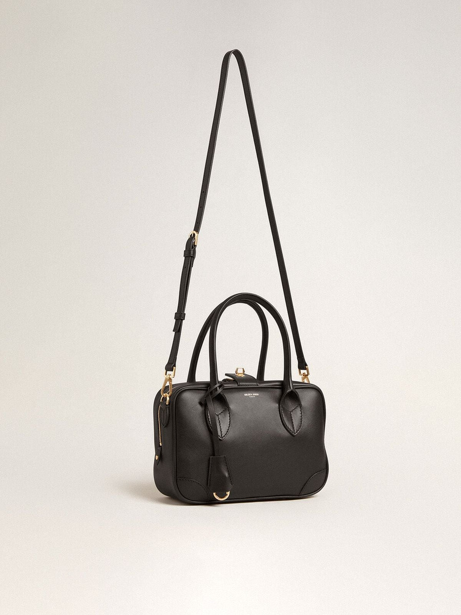 vita-tas van glad zwart leer met gouden details.