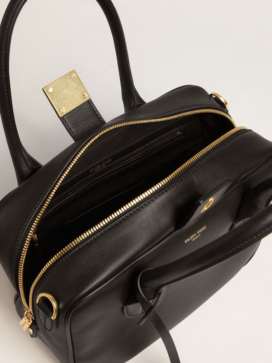 vita-tas van glad zwart leer met gouden details.