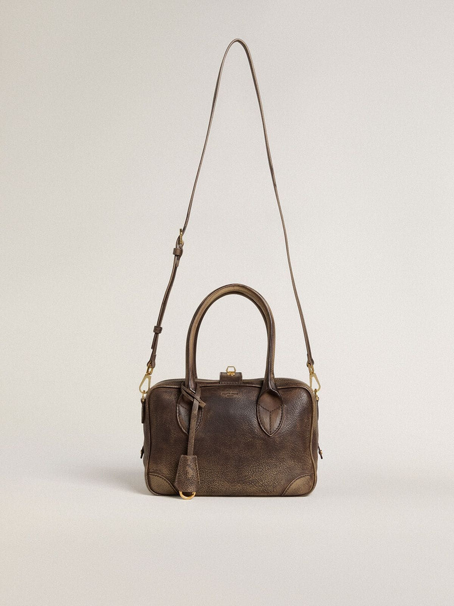vita-tas van bruin vintage leer met gouden details.