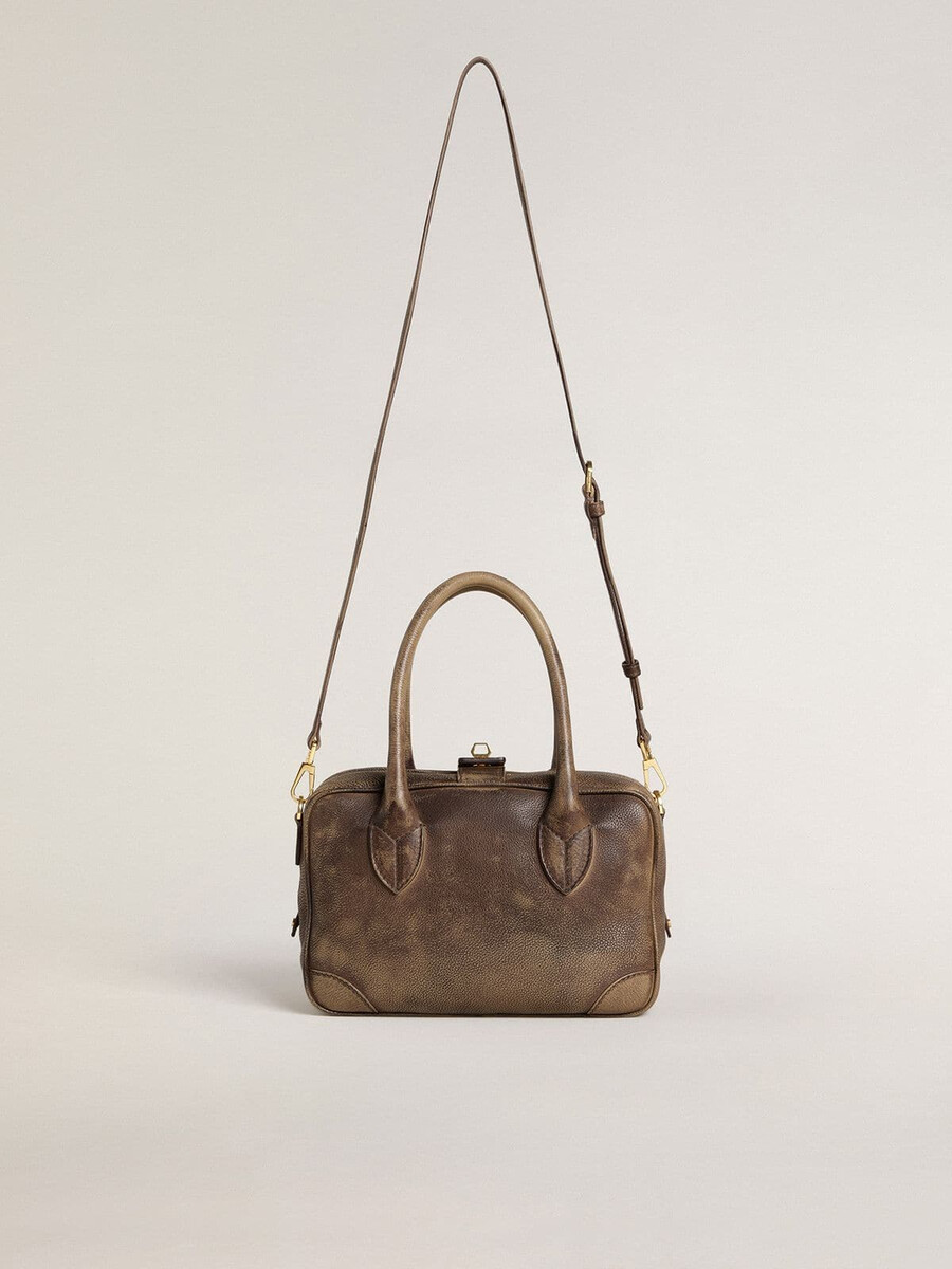vita-tas van bruin vintage leer met gouden details.