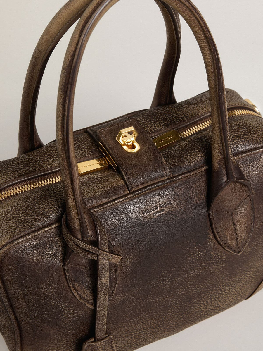 vita-tas van bruin vintage leer met gouden details.