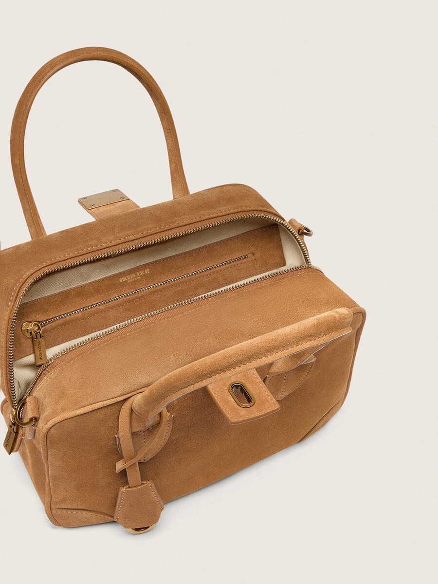 vita-tas van camelkleurig suède met gouden details.